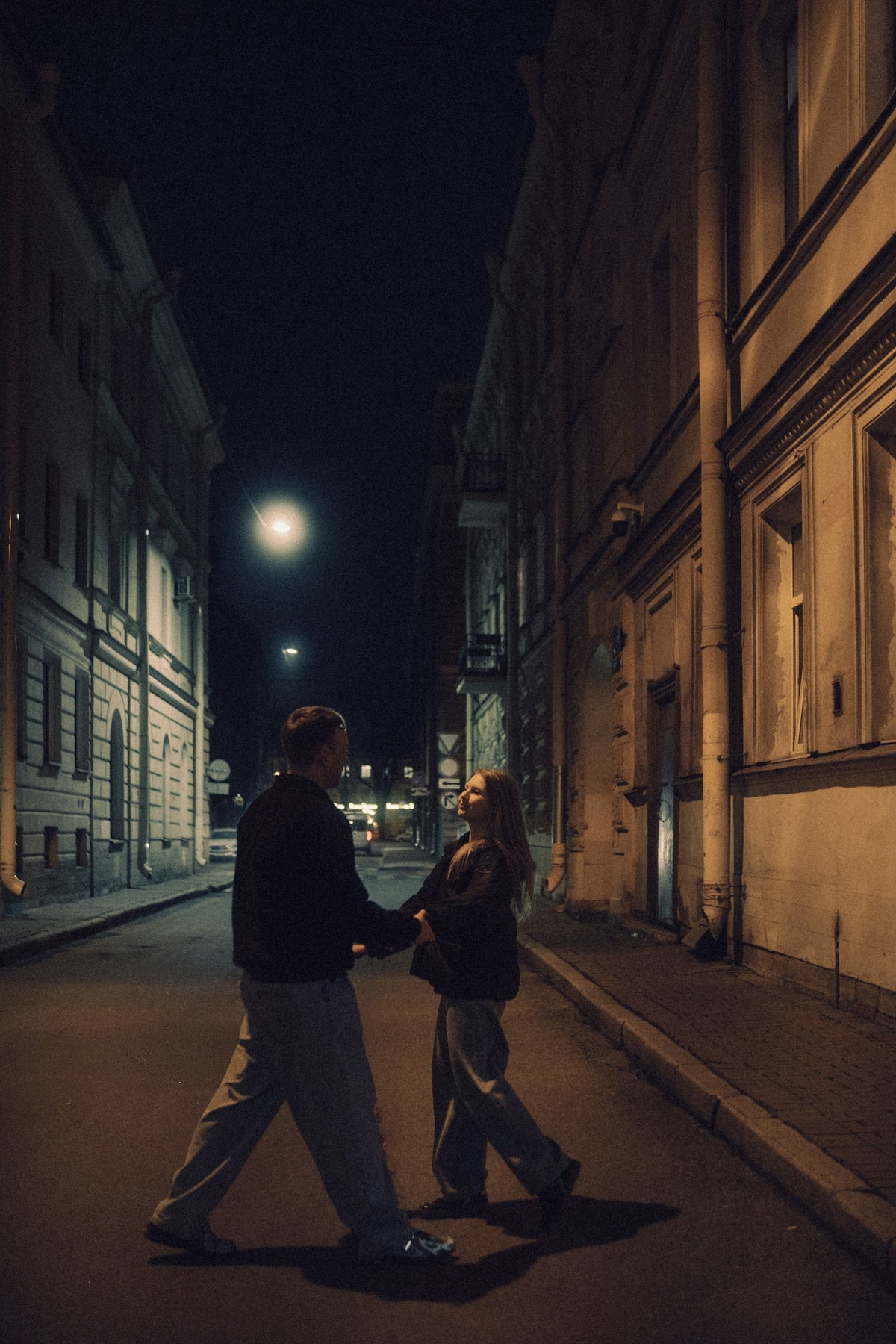 Casal de mãos dadas em uma rua da cidade à noite